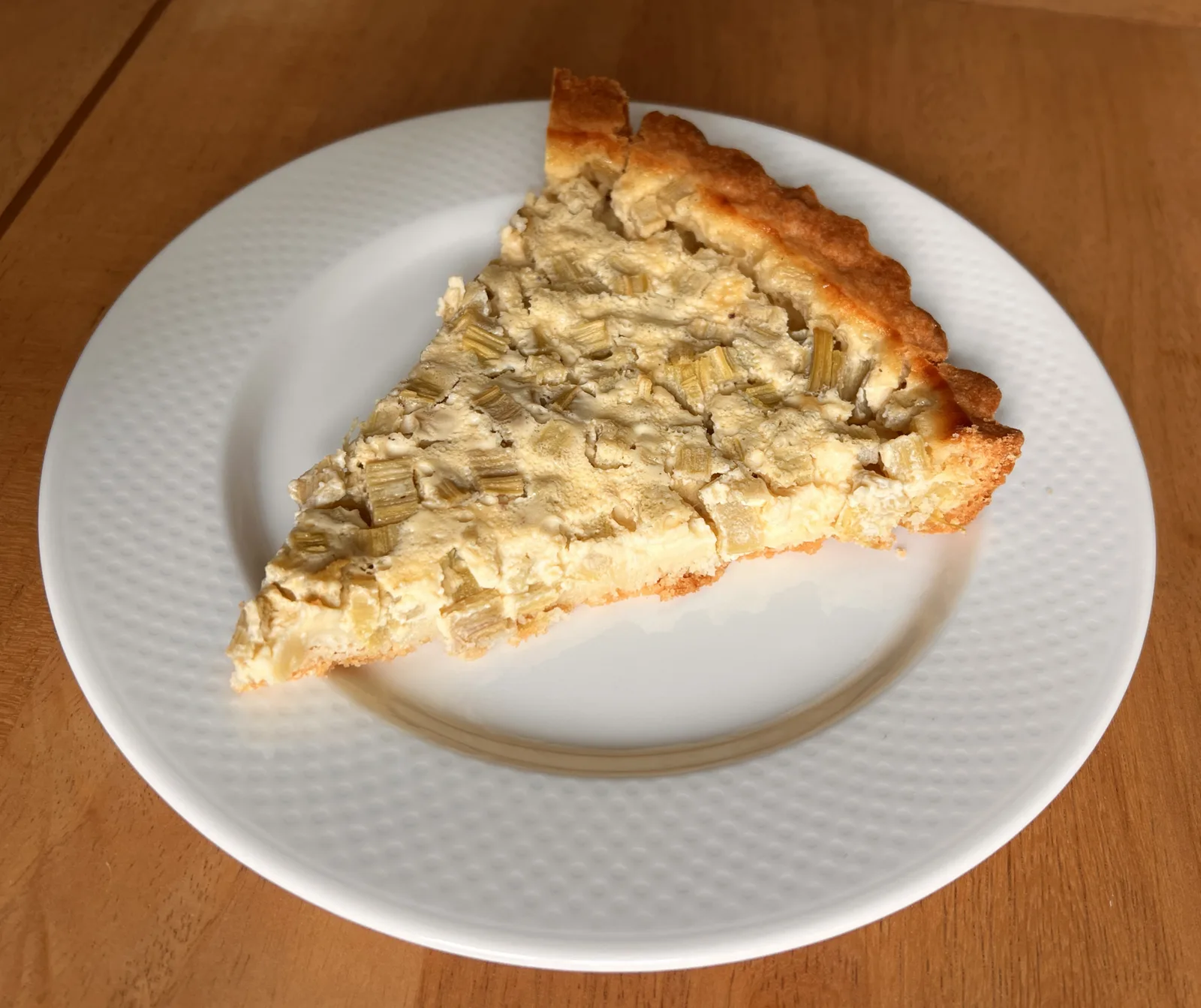Ein Stück Rhabarberkuchen auf einem weißen Teller