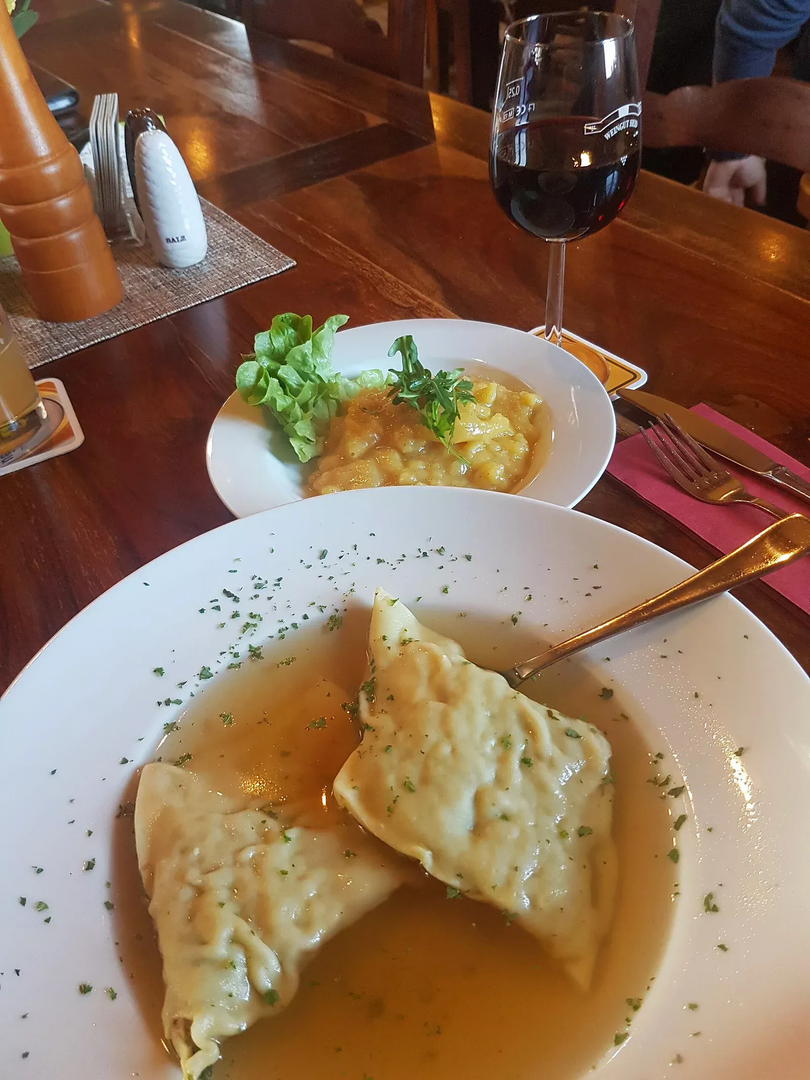 Schwäbische Maultaschen in goldener Brühe serviert mit frischen Kräutern und gebräunter Butter